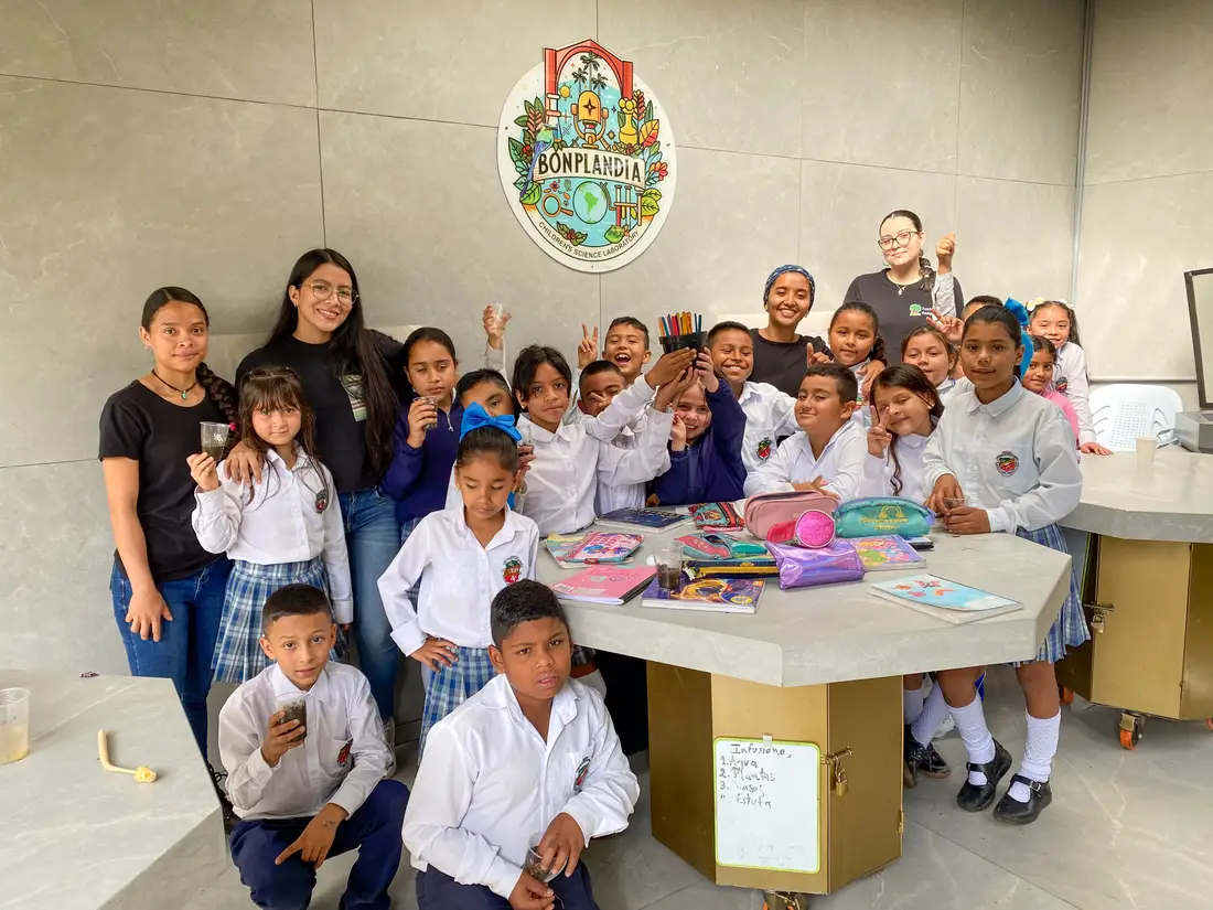 Niños, niñas y las biólogas del programa reunidos frente al emblema del Laboratorio Bonplandia