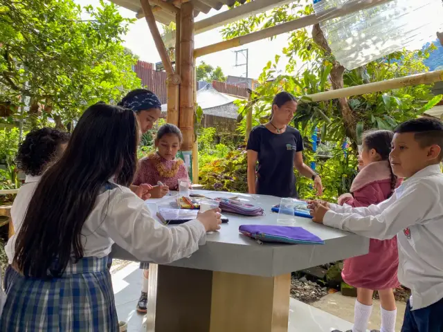 Niños trabajan en la mesa del laboratorio al aire libre, en el Vivero El Patio