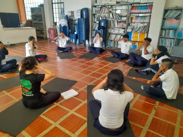 Círculo de meditación durante una sesión de yoga en la biblioteca escolar