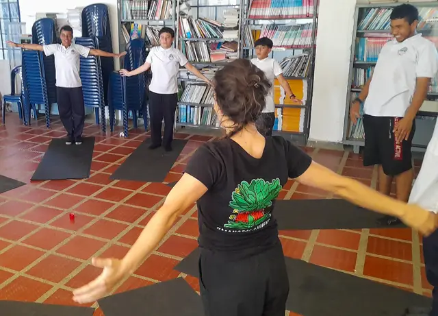 La instructora guía los estiramientos de un grupo de estudiantes